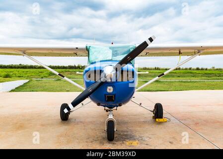 Una Cessna 152 stazionata nel grembiule di fronte ad un hangar Foto Stock