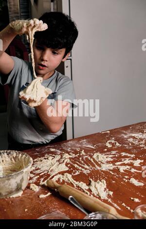 bambino che prepara l'impasto per la pizza da preparare a casa Foto Stock