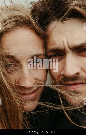 vicino a uomo e donna con gli occhi accanto a. l'un l'altro e i capelli ventosi Foto Stock