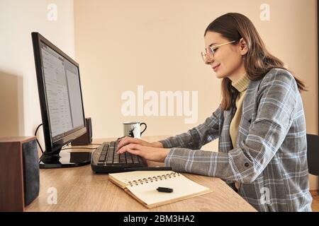 Ritratto di contenuto donna matura seduti alla scrivania a casa Foto Stock