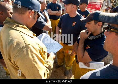 Bastrop, Texas USA, 9 settembre 2011: I vigili del fuoco di Dallas, Texas, si riuniscono al di fuori del Bastrop Convention Center prima di essere inviati in aree rurali colpite da massicci incendi all'inizio di settembre. Vigili del fuoco provenienti da tutto lo stato sono venuti in aiuto di funzionari locali sopraffatti. ©Marjorie Kamys Cotera/Daemmrich Photography Foto Stock