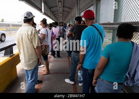 Matamoros, Messico. 06th May, 2020. Centinaia di persone accodate per entrare negli Stati Uniti sul ponte che porta a Brownsville, Texas. La coda a destra è per i titolari di passaporto non USA per entrare negli Stati Uniti, la sinistra è per i titolari di passaporto degli Stati Uniti. La gente in coda aveva aspettato più di 5 ore e non era ancora a metà strada attraverso il ponte. Credit: Lexie Harrison-Cripps/Alamy Live News Foto Stock