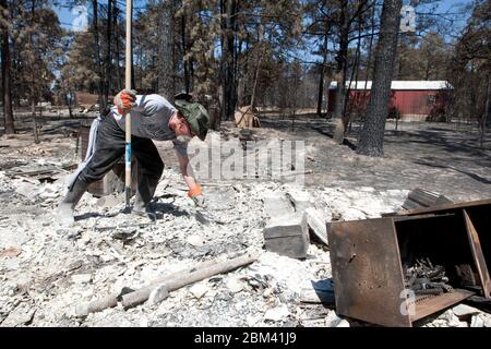 Bastrop Texas USA, settembre 2011: La famiglia passa attraverso la casa danneggiata dopo massicci incendi boschivi spazzati attraverso quartieri boscosi, bruciando più di 1400 case nella zona all'inizio di settembre. ©Marjorie Kamys Cotera/Daemmrich Photography Foto Stock