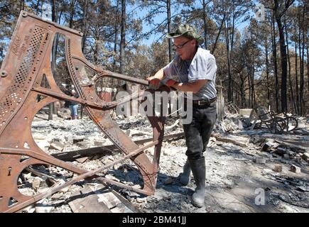 Bastrop Texas USA, settembre 2011: La famiglia passa attraverso la casa danneggiata dopo massicci incendi boschivi spazzati attraverso quartieri boscosi, bruciando più di 1400 case nella zona all'inizio di settembre. ©Marjorie Kamys Cotera/Daemmrich Photography Foto Stock