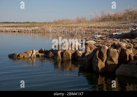 Falcon Lake Texas USA, novembre 2011: Bassi livelli d'acqua causati da una continua siccità espongono rocce e pennellano sul lato degli Stati Uniti del lago Falcon sul confine Texas-Messico a sud di San Antonio. Un paradiso per i pescatori di spigole, Falcon Lake ha visto un aumento negli scontri tra presunti operatori messicani del cartello della droga e pescatori dopo l'uccisione di un cittadino americano dalla parte messicana nel 2010. ©Bob Daemmrich Foto Stock