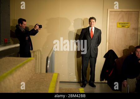 Waukee, Iowa USA, 3 gennaio 2012: Rick Perry, governatore del Texas e candidato alla nomina presidenziale repubblicana, attende il backstage mentre un aiutante della campagna lo fotografa prima di parlare ad un caucus dell'Iowa alla Chiesa di Point of Grace in un sobborgo di Des Moines. ©Bob Daemmrich Foto Stock