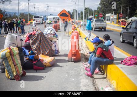 Immigrati per le strade di Bogotà con valigie in attesa di tornare nel loro paese, il Venezuela, a causa della diffusione del virus della corona pandemica, COVI Foto Stock