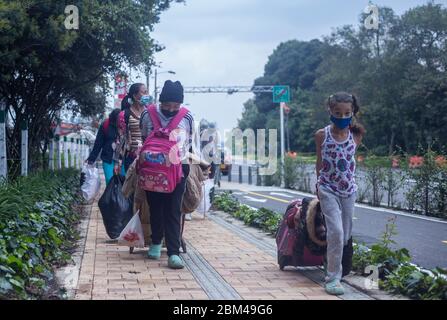 Immigrati per le strade di Bogotà con valigie in attesa di tornare nel loro paese, il Venezuela, a causa della diffusione del virus della corona pandemica, COVI Foto Stock