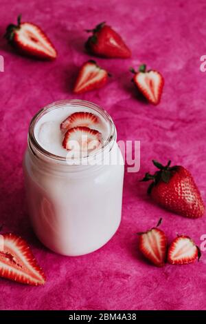 Frullato di fragole in vaso di vetro sfondo rosa Foto Stock