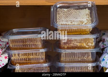 Fette di Honeycomb giallo confezionate in scatole di plastica primo piano durante il mercato alimentare festival, per la vendita. Prodotto biologico naturale, dolcificante naturale, zucchero f Foto Stock