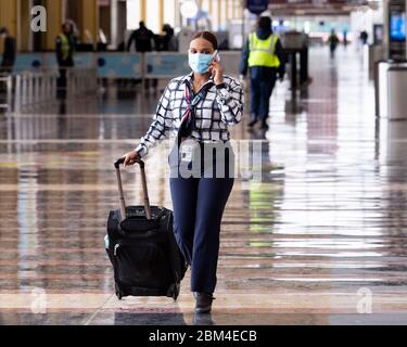 Arlington, Stati Uniti. 06 maggio 2020. Un assistente di volo che indossa una maschera facciale come misura preventiva cammina in un atrio molto non affollato all'Aeroporto Nazionale Ronald Reagan di Washington durante la crisi del coronavirus. Credit: SOPA Images Limited/Alamy Live News Foto Stock