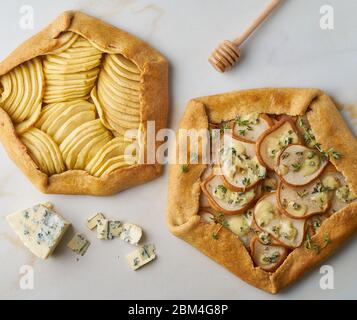 Galette di frutta, torta di mele con miele, torta di pere e formaggi salati, tavolo in marmo, vista dall'alto Foto Stock