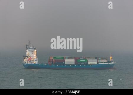 Myrtleville, Cork, Irlanda. 7 maggio 2020. Nave portacontainer Greetje ancorata al largo della costa in nebbia a Myrtleville, Co. Cork con un carico da Southampton nel Regno Unito. In tempi critici durante l'emergenza del Covid-19 l'economia irlandese dipende dalle importazioni che costituiscono un'ancora di salvezza per il paese. Mantenere aperta questa linea di approvvigionamento vitale è il porto di Cork, dove arriva la maggior parte delle importazioni dei paesi. - credito; David Creedon / Alamy Live News Foto Stock