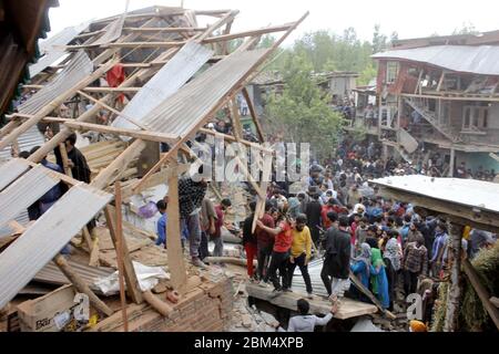 Pulwama, India. 06 maggio 2020. La gente si trova vicino ai detriti di una casa nella zona di Awantipora, a sud del Kashmir, il mercoledì. Le forze governative hanno ucciso un comandante ribelle e il suo aiuto e hanno chiuso i servizi di telefonia mobile e internet durante le proteste anti-India successive (Foto di Muneeb ul Islam / Pacific Press) Credit: Pacific Press Agency/Alamy Live News Foto Stock