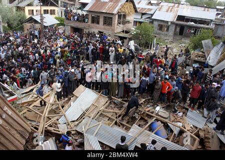 Pulwama, India. 06 maggio 2020. La gente si trova vicino ai detriti di una casa nella zona di Awantipora, a sud del Kashmir, il mercoledì. Le forze governative hanno ucciso un comandante ribelle e il suo aiuto e hanno chiuso i servizi di telefonia mobile e internet durante le proteste anti-India successive (Foto di Muneeb ul Islam / Pacific Press) Credit: Pacific Press Agency/Alamy Live News Foto Stock