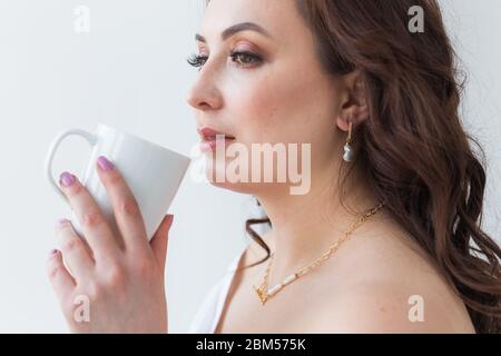 Mano della donna che tiene una tazza bianca di caffè. Con un bellissimo manicure primo piano. Drink, moda, mattina Foto Stock