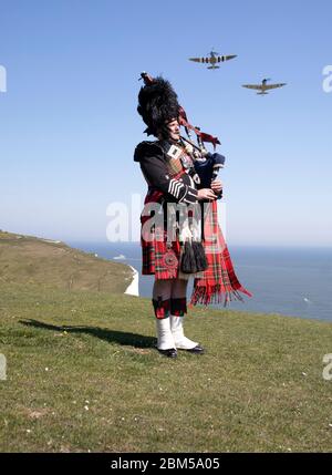 EMBARGOED A 0001 VENERDÌ 08 MAGGIO tubo maggiore Andy Reid delle Guardie scozzesi gioca le sue pipe sulle scogliere di dover, Kent, come due Spitfire dalla Battaglia di Gran Bretagna Memorial volo aereo, in anticipo rispetto alle commemorazioni per celebrare il 75 ° anniversario di VE Day. Foto Stock