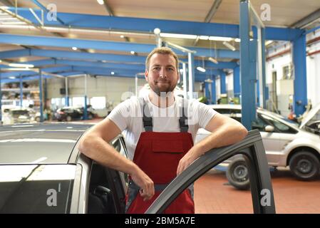 Ritratto di un meccanico sorridente in un laboratorio professionale - foto di primo piano Foto Stock