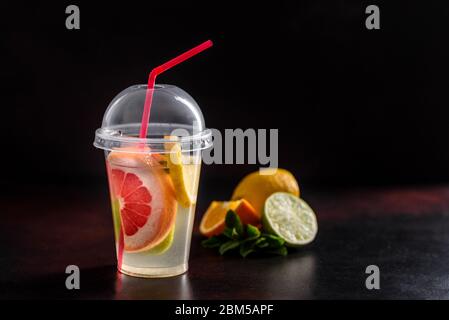 Tè caldo di frutta con limone, menta, arancia, lime e pompelmo in una bella teiera di vetro Foto Stock