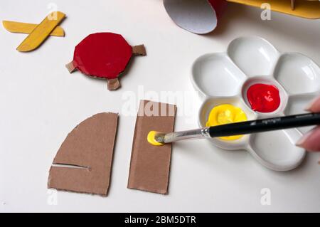 Come fare l'aereo. Giocattolo fatto a mano, zero sprechi da rotolo di carta igienica e bastoncini di papicolo. Per bambini e genitori. Fase 17, vernice dettagli coda giallo Foto Stock