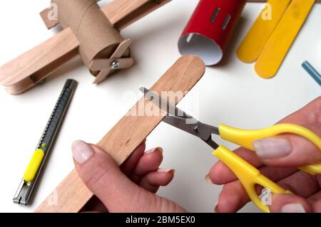 Come fare l'aereo. Giocattolo fatto a mano, zero sprechi da rotolo di carta igienica e bastoncini di papicolo. Per bambini e genitori. Fase 19 taglio del dettaglio dell'aeromobile ad elica Foto Stock