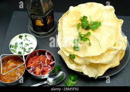 Una pila di papadumi con una selezione di sottaceti Foto Stock