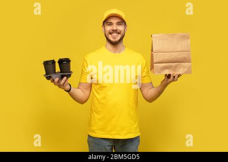 servizio di consegna, fast food e people concept - uomo felice con caffè e sacchetto di carta usa e getta Foto Stock