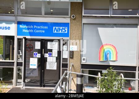 Health Center con segnali di avvertimento e disegno dell'arcobaleno durante il blocco di Coronavirus, Norwich UK aprile 2020 Foto Stock