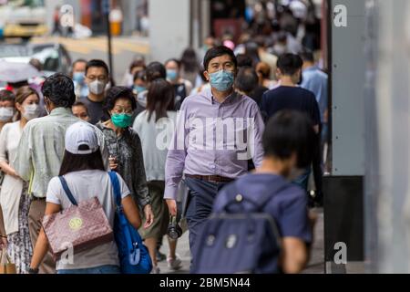 Hong Kong, Hong Kong. 7 maggio 2020 gli Hongkongers indossano maschere chirurgiche per le strade, in mezzo alla pandemia di coronavirus. Oggi è l'ultimo giorno prima che il governo HK sollevi alcune delle restrizioni pubbliche. Hong Kong ha avuto un periodo di 18 giorni di assenza di infezioni trasmesse localmente. Credit: David ogg/Alamy Live News Foto Stock