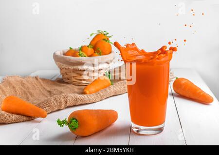 Creativo. Succo di carota. Spruzzi di foto estiva brillante Foto Stock