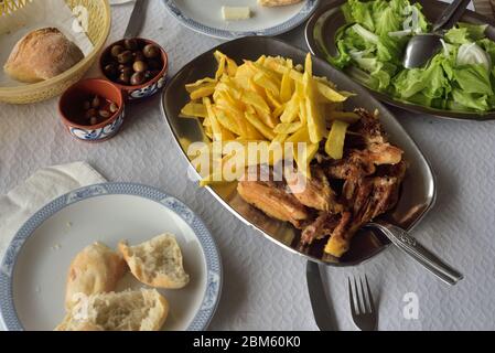 Un pasto semplice in un bar sulla strada in Portogallo - pollo alla griglia, patatine fritte, pane, olive, insalata Foto Stock