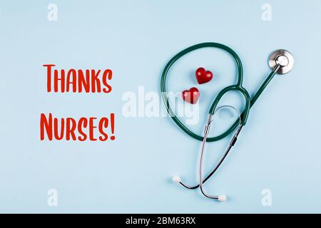 Grazie scheda infermieri. Stetoscopio medico, due cuori rossi. Concetto di medicina sanitaria. Vista dall'alto, disposizione piatta. Foto Stock