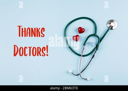 Grazie scheda del medico. Stetoscopio medico, due cuori rossi. Concetto di medicina sanitaria. Vista dall'alto, disposizione piatta. Foto Stock