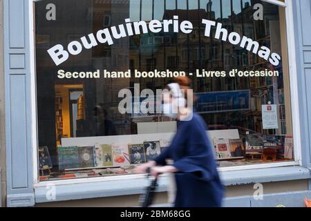 (200507) -- BRUXELLES, 7 maggio 2020 (Xinhua) -- UNA donna che indossa una maschera fa un giro in bicicletta davanti ad un negozio chiuso di libri a Bruxelles, Belgio, 14 aprile 2020. La Commissione europea ha affermato in una previsione economica che, nonostante una risposta politica sia a livello dell'Unione europea (UE) che a livello nazionale, quest'anno l'economia dell'UE subirà una recessione di proporzioni storiche a causa della pandemia di coronavirus. Prevede che l'economia dell'area dell'euro si contraggerà di un record del 7.75 per cento nel 2020 e crescerà del 6.25 per cento nel 2021. Si prevede che l'economia dell'UE si contraraggerà del 7.5 per cento nel 2020 e crescerà di circa Foto Stock