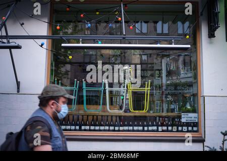 (200507) -- BRUXELLES, 7 maggio 2020 (Xinhua) -- UN uomo che indossa una maschera facciale passa davanti ad un ristorante chiuso a Bruxelles, Belgio, 17 aprile 2020. La Commissione europea ha affermato in una previsione economica che, nonostante una risposta politica sia a livello dell'Unione europea (UE) che a livello nazionale, quest'anno l'economia dell'UE subirà una recessione di proporzioni storiche a causa della pandemia di coronavirus. Prevede che l'economia dell'area dell'euro si contraggerà di un record del 7.75 per cento nel 2020 e crescerà del 6.25 per cento nel 2021. Si prevede che l'economia dell'UE subappalterà il 7.5 per cento nel 2020 e crescerà di circa il 6 per cento Foto Stock