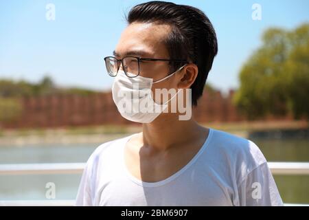 Uomo che indossa una maschera igienica per prevenire le infezioni. Foto Stock