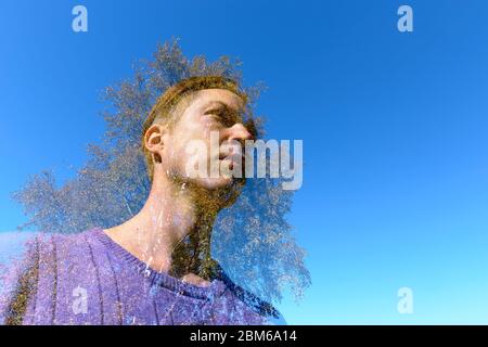 Doppia esposizione di giovane uomo bello e quercia sovrastante contro il cielo blu Foto Stock