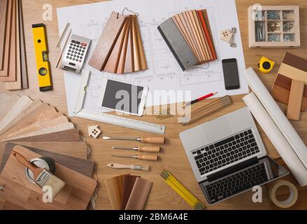 Architetto e home arredatore desktop con strumenti, laptop, campioni di legno e home il progetto progetto, vista dall'alto Foto Stock