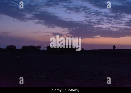 Silhouette di capanne nel deserto di Danakil al crepuscolo, Etiopia Foto Stock