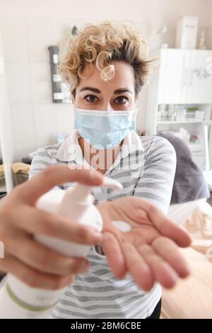 Zinnowitz, Germania. 7 maggio 2020. INA Schudrewitz, estetista, si trova presso lo studio di cosmetici Harmonie sul mare, indossando una maschera facciale. Dopo un orario di chiusura di otto settimane, il Meclemburgo-Pomerania occidentale ha consentito la riapertura di fornitori di servizi quali studi cosmetici e chiodi, saloni di chiopody, massaggi, studi di sole e tatuaggio dal 7 maggio 2020. Credit: Stefan Sauer/dpa-Zentralbild/dpa/Alamy Live News Foto Stock