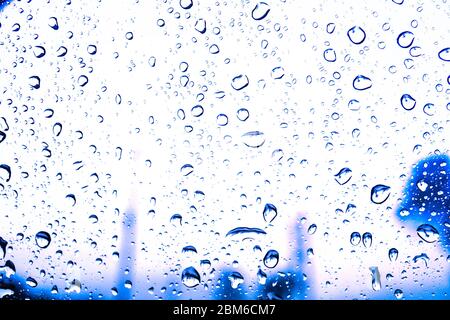 gocce d'acqua sulla finestra di vetro con luci bokeh Foto Stock