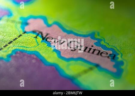 Profondità di campo poco profonda fuoco sulla mappa geografica posizione del paese Papua Nuova Guinea in Asia Oceania continente su atlas Foto Stock