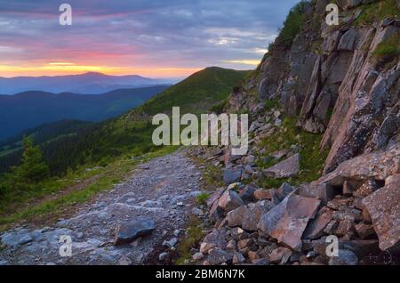 Strada in pietra in montagna. Alba colorata. Paesaggio estivo. Carpazi, Ucraina, Europa Foto Stock