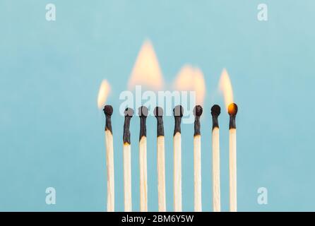 Un primo piano di otto fiammiferi brucianti Foto Stock