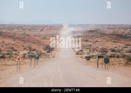 Le auto si buttano via sulla strada C35 in ghiaia nella regione di Tsideb, Namibia, Africa Foto Stock