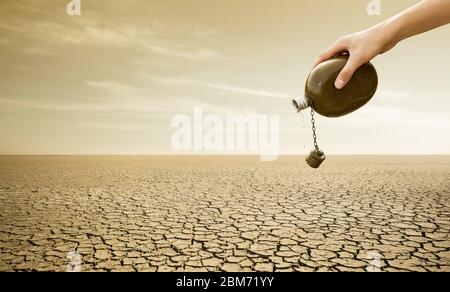 Uomo con fiasca nel deserto. Siccità e scarsità di acqua causate dal riscaldamento globale Foto Stock
