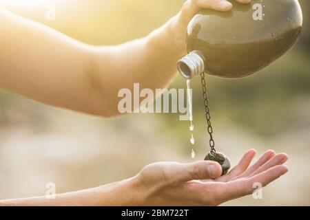 Uomo con fiasca nel deserto. Siccità e scarsità di acqua causate dal riscaldamento globale Foto Stock