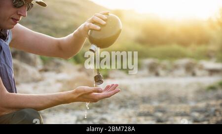 Uomo con fiasca nel deserto. Siccità e scarsità di acqua causate dal riscaldamento globale Foto Stock