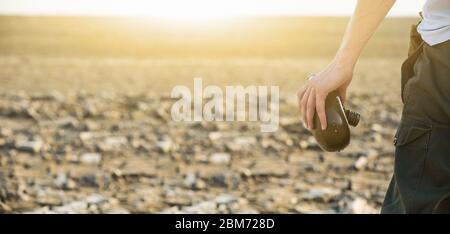 Uomo con fiasca nel deserto. Siccità e scarsità di acqua causate dal riscaldamento globale Foto Stock