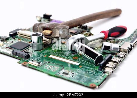 Vecchio martello e una chiave su un vecchio microcircuito per un computer su sfondo bianco, primo piano Foto Stock